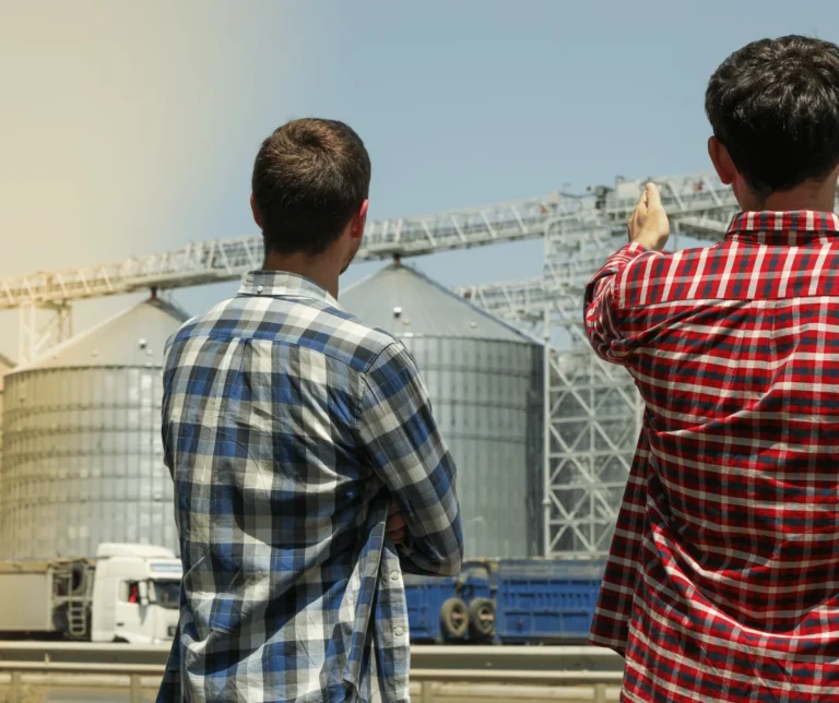 Profissionais em frente a silos de armazenagem de grãos com caminhões: locação de impressoras da MarqueSys para o agronegócio em Uberlândia