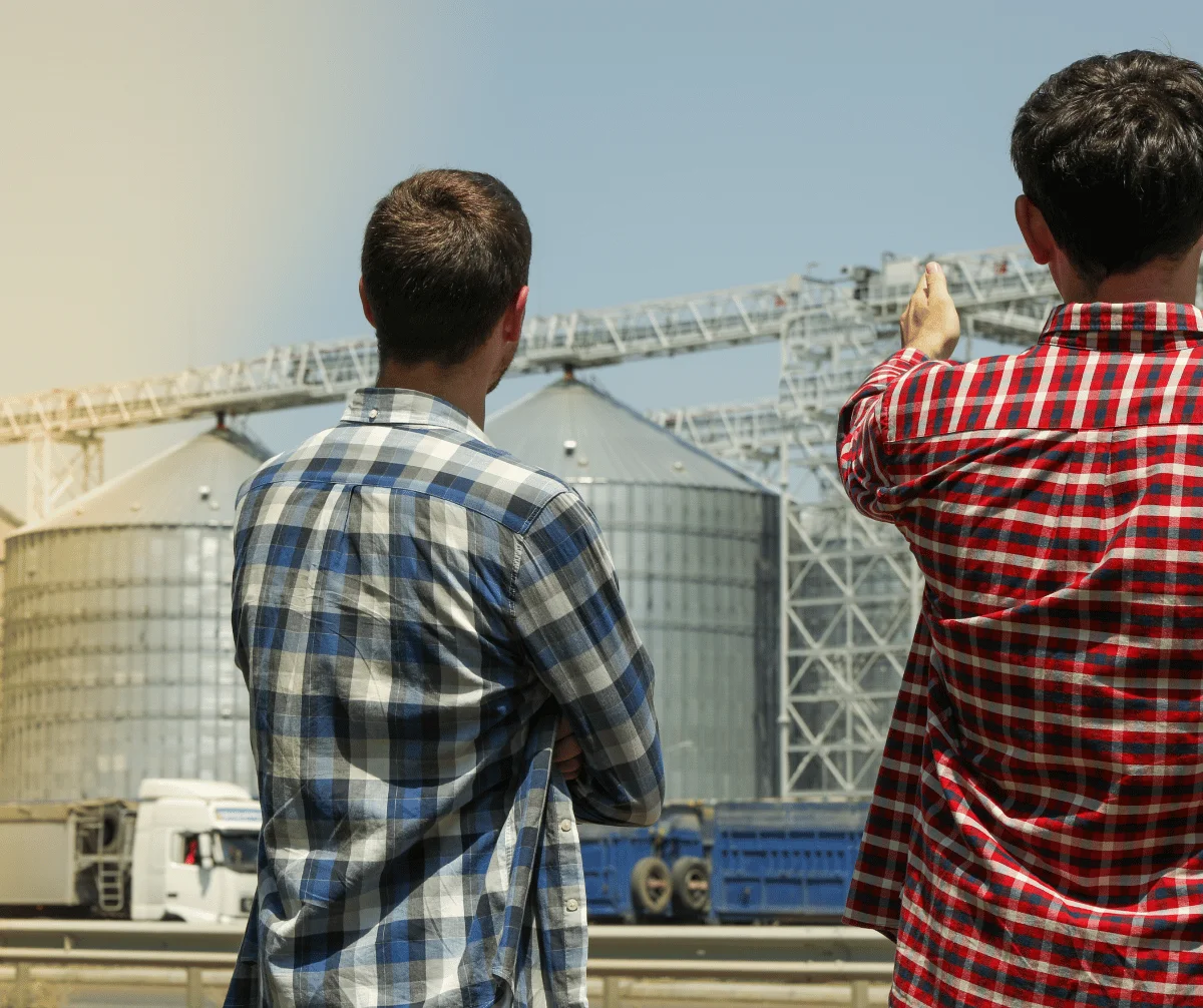 Profissionais em frente a silos de armazenagem de grãos com caminhões: locação de impressoras da MarqueSys para o agronegócio em Uberlândia
