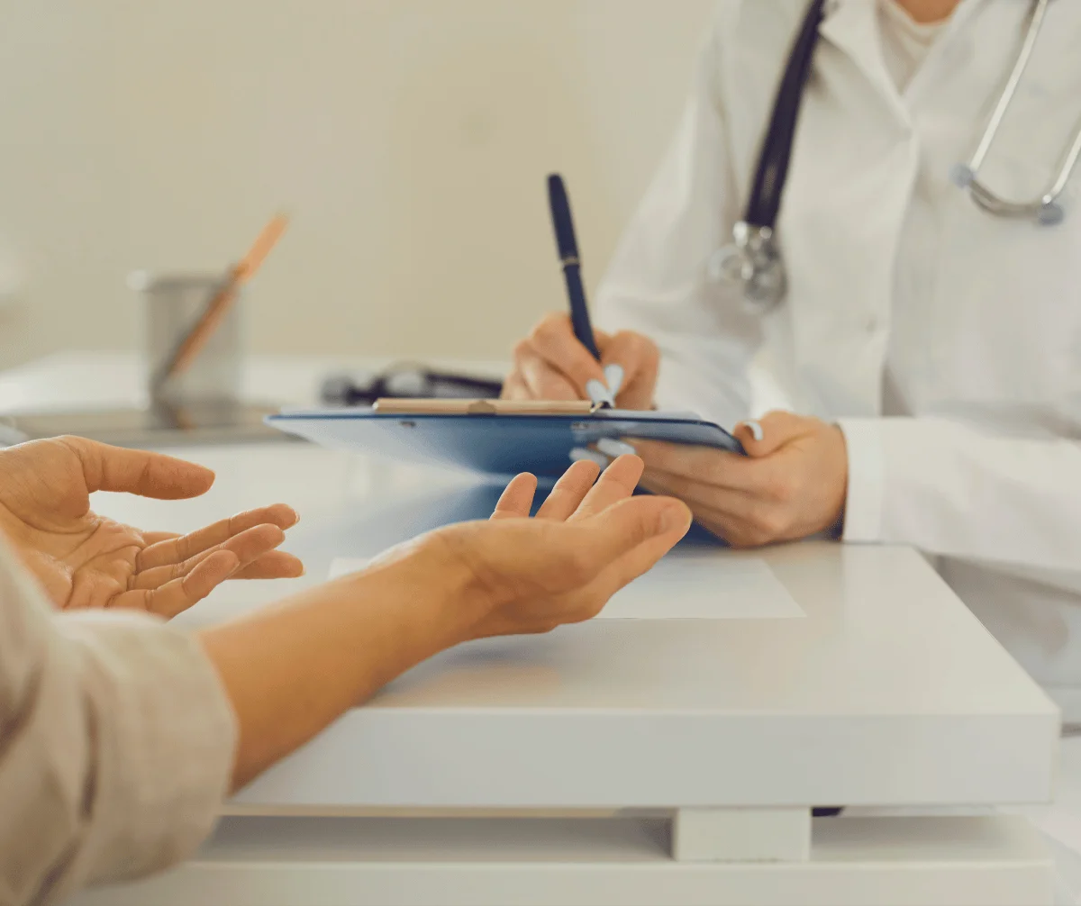 Médica preenchendo documento durante atendimento em clínica: locação de impressoras da MarqueSys em Uberlândia